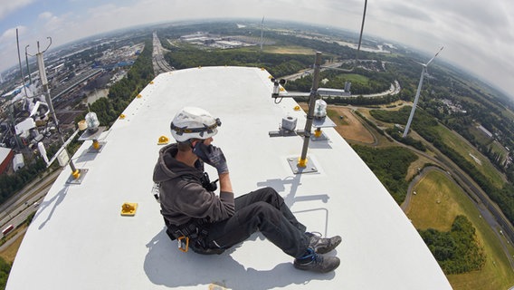 Ein Technical Operator telefoniert während eines Einsatzes auf einer Windenergieanlage von «Hamburg Energie» auf dem IBA-Energieberg, der ehemaligen Mülldeponie Georgswerder. © picture alliance Foto: Georg Wendt