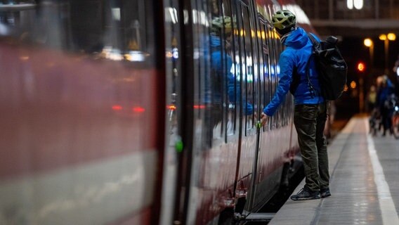 Ein Mann steigt in eine Regionalbahn. © picture alliance/dpa | Hendrik Schmidt Foto: Hendrik Schmidt