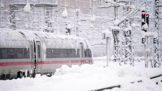 Ein ICE steht nach starkem Schneefall am Hauptbahnhof in München. © Matthias Schrader/AP/dpa Foto: Matthias Schrader/AP/dpa