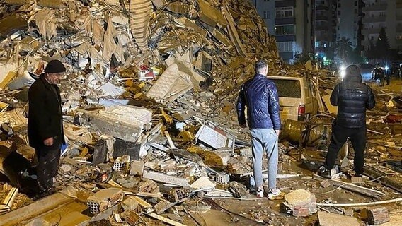 Menschen suchen in Trümmern eines von Erdbeben zerstörten Gebäudes in Diyarbakir im Süden der Türkei nach Verletzten © dpa-Bildfunk Foto: Uncredited/Depo Photos/AP/dpa