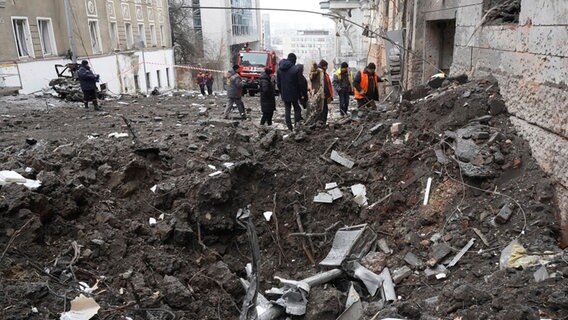 Rettungskräfte und städtische Mitarbeiter räumen die Trümmer eines von einer russischen Rakete getroffenen Wohnhauses in Charkiw. © dpa-Bildfunk Foto: Andrii Marienko/AP/dpa