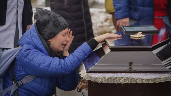 Trauernde in der ukrainischen Stadt Charkiw, nachdem eine Familie bei einem russischen Drohnen-Angriff starb. © Andrii Marienko/AP/dpa Foto: Andrii Marienko/AP/dpa