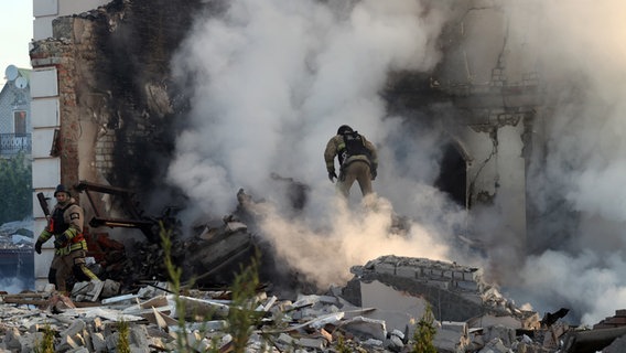 Ein Feuerwehrmann geht durch den Qualm eines brennenden Hauses, nach russischen Beschuss. © Ukrinform/dpa 
