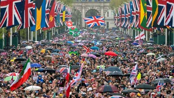 Menschen versammeln sich an der Straße "The Mall" in London während der Krönung von König Charles III. und Königin Camilla. © dpa bildfunk/Daily Mail Pool/AP Foto: Foto: Roland Hoskins
