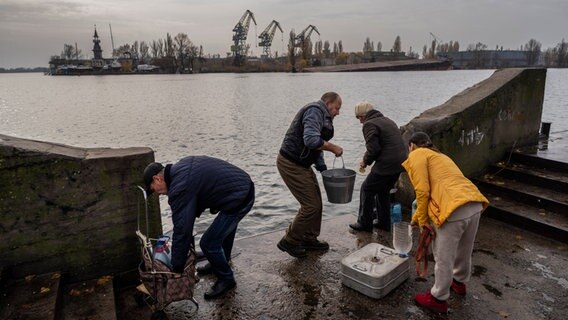 Bewohner holen Wasser vom Ufer des Flusses Dnipro im Süden der Ukraine. © Bernat Armangue/AP/dpa 