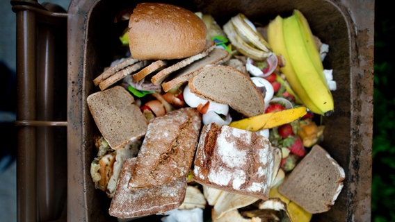 Lebensmittel wie Brot liegen in einer braunen Mülltonne © dpa Foto: Arno Burgi