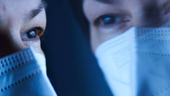 Eine Frau mit FFP2-Maske lehnt mit ihrem Gesicht an der Fensterscheibe und guckt hinaus. © Imago | Action Pictures Foto: Action Pictures