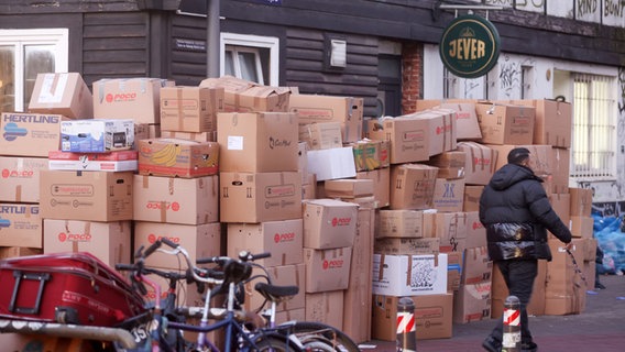 Kartons mit sortierten Spenden stehen im Rahmen einer privaten Spendenaktion vor einer geschlossenen Bar in Hamburg-Altona. © dpa/Bodo Marks Foto: Bodo Marks
