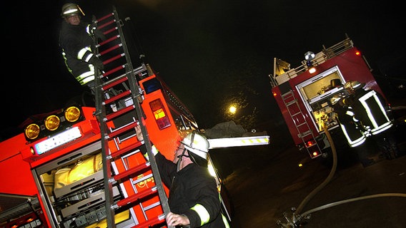 Feuerwehrmänner entladen eine Leiter © imago / nordpool / Tittel 