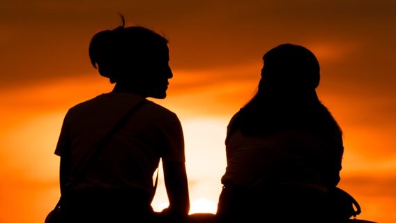 Silhouette zweier Frauen vor Sonnenuntergang © picture alliance/dpa Foto: Silas Stein, dpa