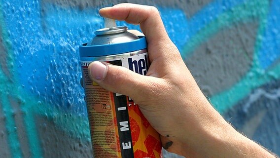 Ein Graffiti-Sprayer besprüht eine Mauer © dpa Foto: Tobias Felber
