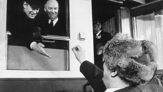 SED-Chef Erich Honecker (rechts) schenkt Bundeskanzler Helmut Schmidt (links) nach dessen DDR-Besuch bei seiner Abreise am 13. Dezember 1981 auf dem Bahnhof von Güstrow ein Lutschbonbon vom Weihnachtsmarkt. © dpa - Bildfunk Foto: Dieter Klar