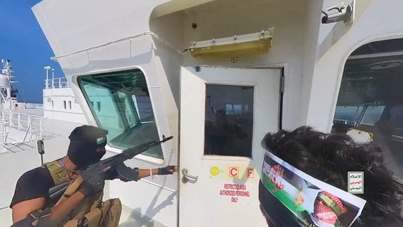 Ein Handout-Foto, das am 21. November 2023 vom Huthi Military Media Center zur Verfügung gestellt wurde, zeigt Huthi-Rebellen an Deck des Frachtschiffs "Galaxy Leader". © picture alliance/dpa/Houthi Military Media Center 