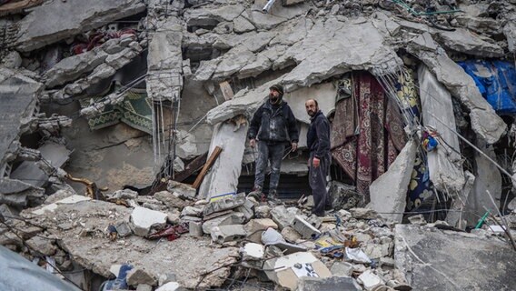 Syrische Zivilisten und Mitglieder der Weißhelme bei der Rettung von nach dem Erdbeben Verschütteten in der Stadt Idlib. © dpa Foto: Anas Alkharboutli