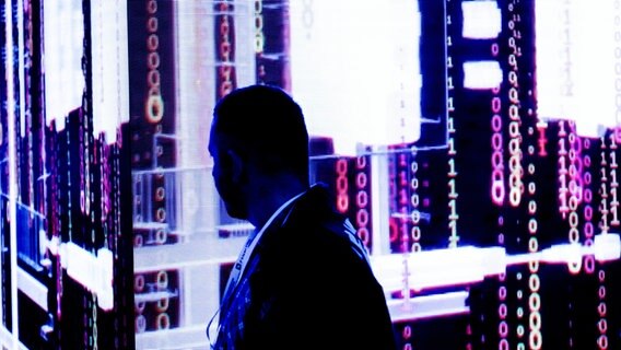 Ein Mann steht vor einem Display, das Nullen und Einsen zeigt. © picture-alliance/dpa Foto: Peter Steffen