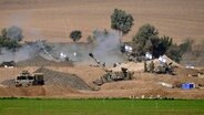 Eine israelische mobile Artillerieeinheit ist in einer Position nahe der Grenze zwischen Israel und Gaza zu sehen. © dpa bildfunk/AP Foto: Tsafrir Abayov