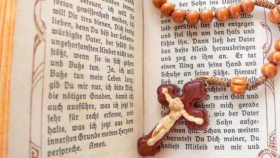 Rosenkranz in aufgeschlagener Bibel © fotolia Foto: Uwe Landgraf
