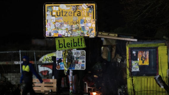 Das Ortsschild von Lützerath ist mit Stickern beklebt. Klimaaktivisten haben den Ort am Braunkohletagebau besetzt. © Oliver Berg/dpa 