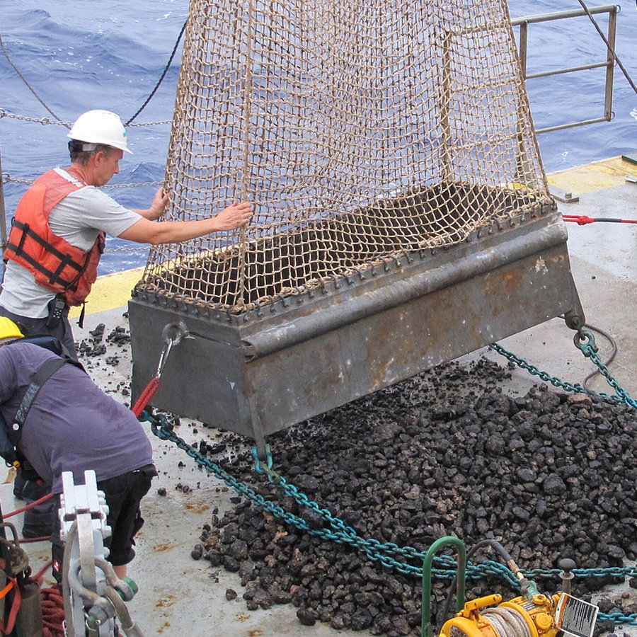 Wissenschaftler schütten Manganknollen aus einem Netz auf ein Forschungsschiff (Themenbild). © picture alliance / BGR 