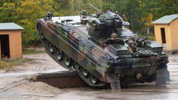 Ein Schützenpanzer der Bundeswehr vom Typ Marder fährt bei einer Übung über ein Hindernis.  