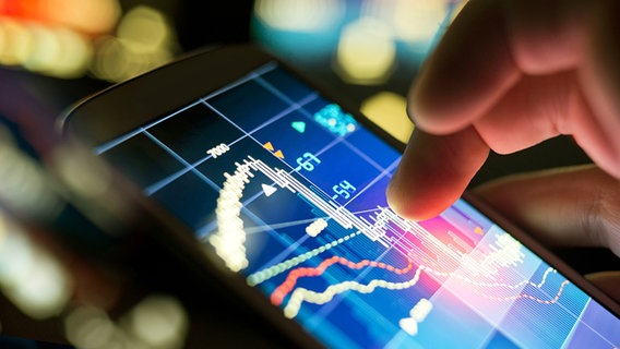 Auf einem Tablet-Computer schaut sich ein Mann Börsen/Aktienkurse an. Dabei streichen seine Finger über die Geräteoberfläche. © Fotolia Foto: James Thew