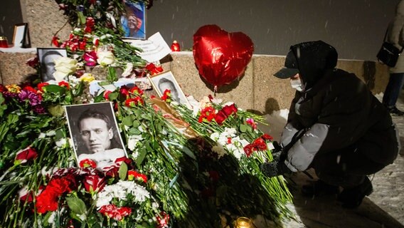 Jemand legt Blumen an einem Gedenkort mit dem Foto des gestorbenen russischen Oppositionellen Nawalny nieder © Artem Priakhin/SOPA Images via ZUMA Press Wire/dpa Foto: Artem Priakhin