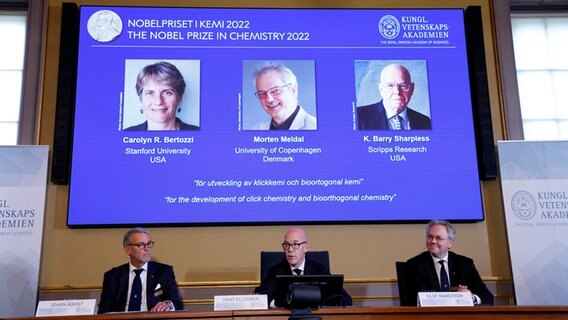Bei einer Pressekonferenz sind die Fotos der drei Gewinner des Nobelpreises für Chemie zu sehen. © Christine Olsson/TT News Agency/dpa 