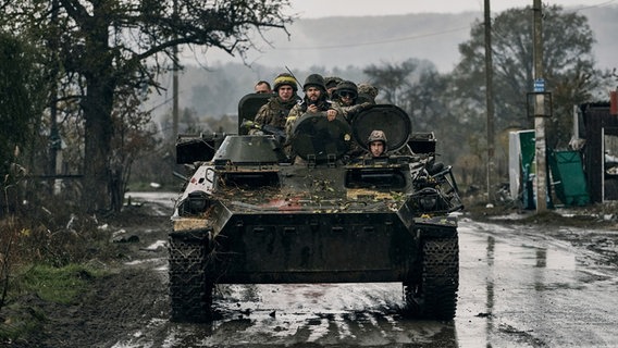 Ukrainische Soldaten fahren in der Region Donezk in einem gepanzerten Fahrzeug. © picture alliance/dpa/AP/LIBKOS 