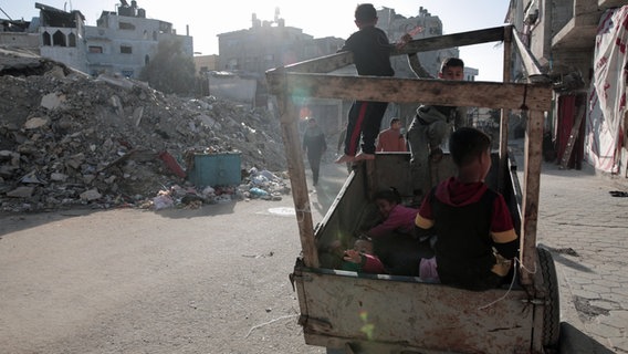 Kinder spielen in der Nähe der Trümmer des Flüchtlingslagers Al-Maghazi im Zentrum des Gazastreifens. © dpa Foto: XinHua