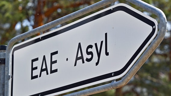 Die Abkürzung und das Wort "EAE Asyl" stehen auf einem Wegweiser zur Erstaufnahme-Einrichtungen (EAE) des Landes Brandenburg in Eisenhüttenstadt. © dpa Foto: Patrick Pleul