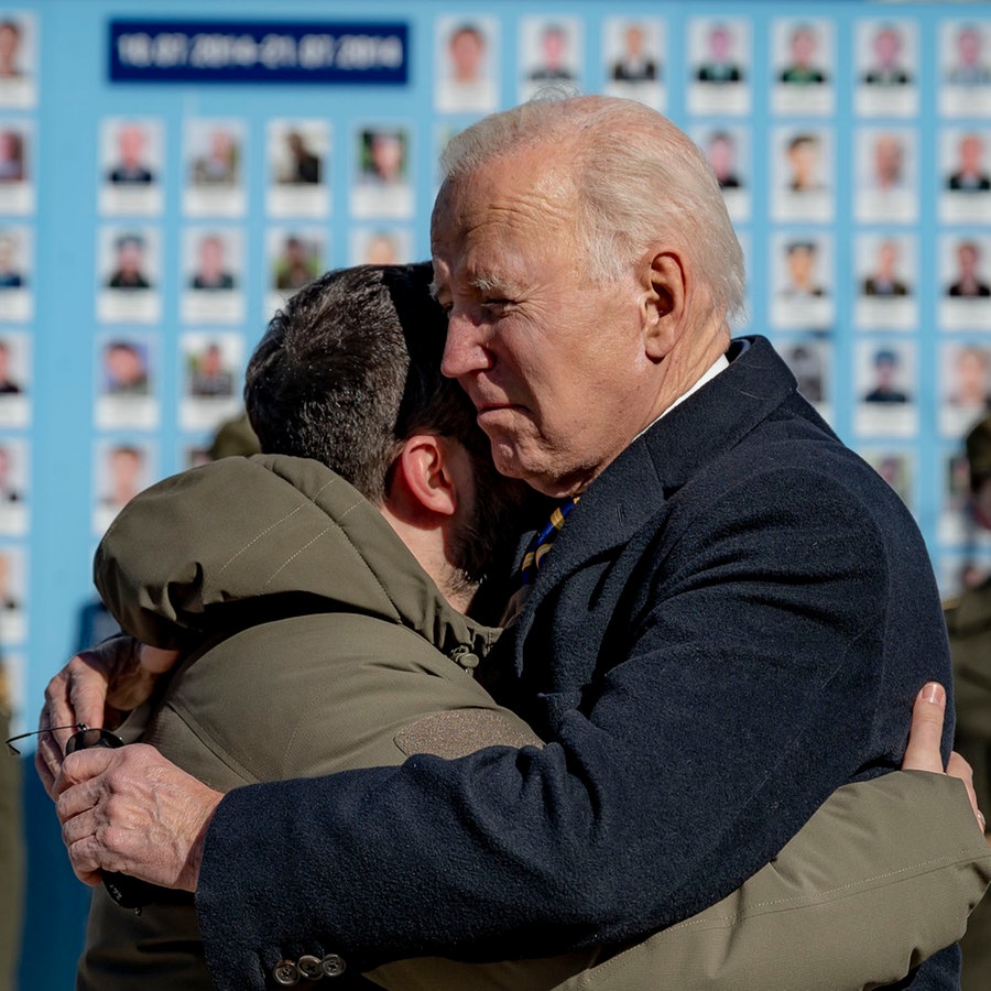 Joe Biden und Wolodymyr Selenskyj umarmen sich zum Abschied an der
Gedenkmauer für die gefallenen Verteidiger der Ukraine. © picture alliance 