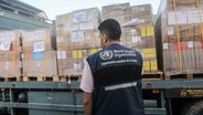 Ein Arbeiter beobachtet die von der Weltgesundheitsorganisation (WHO) gesandten medizinischen Hilfspakete. © dpa Foto: Mohammed Talatene