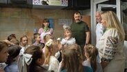 Der Bürgermeister von Charkiw, Ihor Terechow (2. von rechts), besucht am ersten Schultag ein Klassenzimmer, das in einer U-Bahn-Station eingerichtet wurde. © ZUMA Press Wire/dpa Foto: Madeleine Kelly