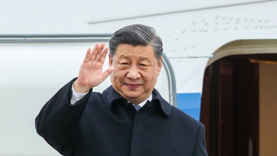 Chinas Präsident Xi Jinping winkt vor einer geöffneten Flugzeugtür © picture alliance / Globa Look Press | Petrov Sergey Foto: Petrov Sergey