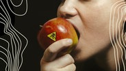 Eine Frau beißt in einen Apfel mit einem gelben Warnsticker. Eine Frau beißt in einen Apfel mit einem gelben Warnsticker. © BR Foto: Monika Rasciute, Hannah Wiesner