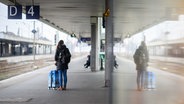 Eine Frau wartet mit einem Koffer am Hauptbahnhof Hannover. © picture alliance/dpa Foto: Julian Stratenschulte