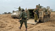 Israelische Soldaten sind in einem Aufmarschgebiet nahe der Grenze zwischen Israel und dem Gazastreifen im Süden Israels zu sehen. © AP/dpa Foto: Ohad Zwigenberg