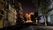 Eine Straße in einem Wohngebiet mit ausgeschalteter Straßenbeleuchtung während einer nächtlichen Ausgangssperre ist leer. © picture alliance/dpa/AP | Foto:  Jae C. Hong