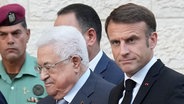 Emmanuel Macron (r), Präsident von Frankreich, winkt als er von Mahmud Abbas, Palästinenserpräsident, empfangen wird. F © dpa-Bildfunk Foto: Christophe Ena