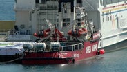 Das Schiff der spanischen Hilfsorganisation "Open Arms" liegt neben einem Fährschiff im Hafen von Larnaca (Zypern). © Uncredited/AP/dpa 