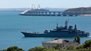 Blick auf ein großes Landungsschiff des russischen Militärs und die Krim-Brücke, die das russische Festland und die Halbinsel Krim über die Straße von Kertsch verbindet. © AP/dpa 