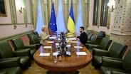 Der Präsident der Ukraine, Wolodymyr Selenskyj (rechts), sitzt mit der Präsidentin der Europäischen Kommission, Ursula von der Leyen (links), für ein bilaterales Einzelgespräch im Mariinsky-Palast an einem Tisch. ©  Ukrainisches Präsidialamt/Planet Pix/Zuma Press/dpa 