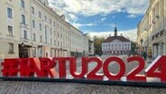 Vor dem Rathaus in Tartu (Estland) steht ein Logo mit der Schrift "#Tartu2024" für die europäische Kulturhauptstadt 2024. © Julia Wäschenbach Foto: Julia Wäschenbach