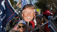 Anhänger von Donald Trump warten in West Palm Beach, Florida, auf den Ex-Präsidenten nach seiner Anklage in New York. © picture alliance Foto: Paul Hennessy