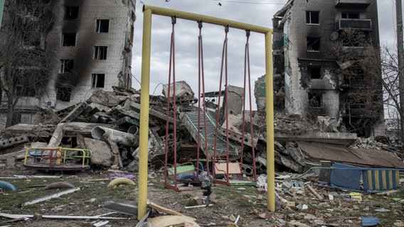 Eine Schaukel steht vor zwei von Bomben zerstörten Hochhäusern © AA | Narciso Contreras Foto: Narciso Contreras