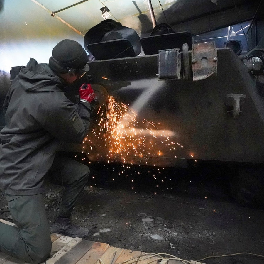 Ein ukrainischer Soldat Nationalgarde entfernt den Buchstaben «Z» von einem erbeuteten Mannschaftstransportwagen. © picture alliance Foto: Andrii Marienko