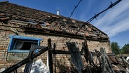 Ein durch russischen Beschuss beschädigtes Wohnhaus im ukrainischen Ort Kushuhum. © picture alliance / Photoshot | - 