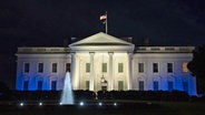 Das Weiße Haus in Washington ist in Blau und Weiß, den Farben der israelischen Flagge, beleuchtet, um die Solidarität der USA mit Israel zu unterstreichen. © AP/dpa Foto: Jon Elswick