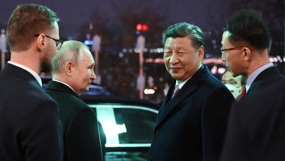 Chinas Staatspräsident Xi Jinping und Russlands Präsident Putin verlassen den Kreml-Palast nach einem gemeinsamen Abendessen. © Associated Press Foto: Grigory Sysoyev