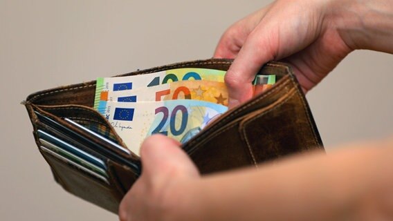 Zwei Hände halten ein geöffnetes Portemonnaie, in dem verschieden Geldscheine stecken © picture alliance / pressefoto_korb | Micha Korb Foto:  Micha Korb
